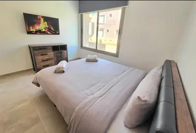 a bedroom with a large bed with two towels on it at Penthouse Prestigia Village Panoramique sur le Lac in Marrakech