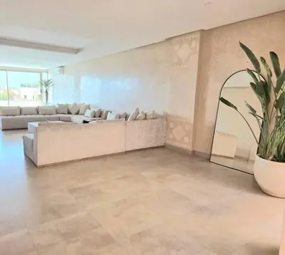 a large living room with couches and a potted plant at Penthouse Prestigia Village Panoramique sur le Lac in Marrakech