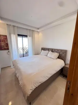 a bedroom with a large bed with a window at Azzizi in Marrakech