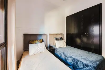 a small room with two beds and a flat screen tv at Cocon au calme Residence Piscine Marrakech in Marrakech
