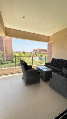 a large living room with couches and a large window at Magnifique appartement in Marrakech