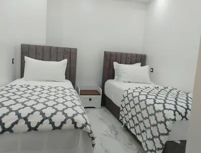 two beds sitting next to each other in a bedroom at Bright Apartment, 10 minutes from Gueliz and 7 minutes from Majorelle Garden in Marrakech