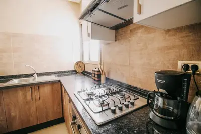 a kitchen with a stove top and a sink at Modern 3BR Luxury Prestigia Golf in Marrakech