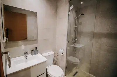 a bathroom with a shower and a toilet and a sink at Modern 3BR Luxury Prestigia Golf in Marrakech