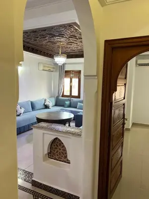 a living room with a blue couch and a table at Stylish 2-Bedroom City Apartment in the city of Marrakech in Marrakech
