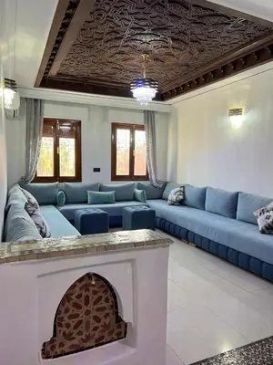 a living room with blue couches and a fireplace at Stylish 2-Bedroom City Apartment in the city of Marrakech in Marrakech
