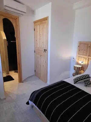 a bedroom with a black and white bed and a door at Riad Douiria MiLa Luxury Private 2 to 4 people in Marrakech