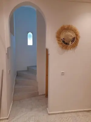 a hallway with stairs and a wreath on the wall at Riad Douiria MiLa Luxury Private 2 to 4 people in Marrakech