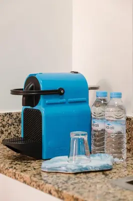 a blue toaster sitting on a counter with two bottles of water at Cozy Mykonos 2BR Apartment in Marrakech