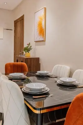 a dining room with a table and orange chairs at Central Luxury Gem marrakech 3BR in Marrakech