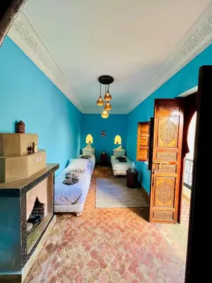 a blue room with a bed and a fireplace at Entire Boutique Riad with 5star Hospitality Breakfast included in Marrakech