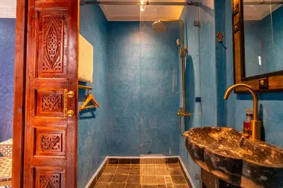 a bathroom with a sink and a wooden door at Entire Boutique Riad with 5star Hospitality Breakfast included in Marrakech