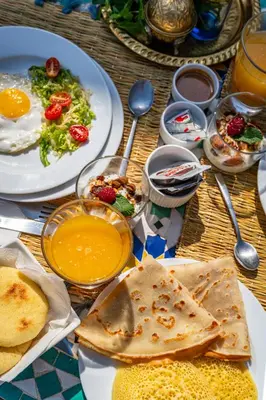 a table topped with plates of food with eggs and bread at Entire Boutique Riad with 5star Hospitality Breakfast included in Marrakech