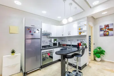 a kitchen with a stainless steel refrigerator and a counter at Cocon Urbain centre-ville et confort in Marrakech