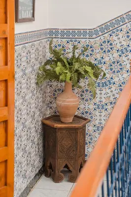 a plant in a vase on a table next to a staircase at Riad Palm Oasis Marrakech in Marrakech