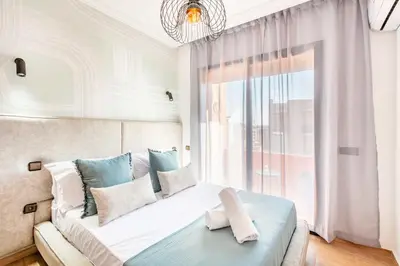 a bedroom with a bed with a large window at Appartement Élégant Quartier Hivernage in Marrakech