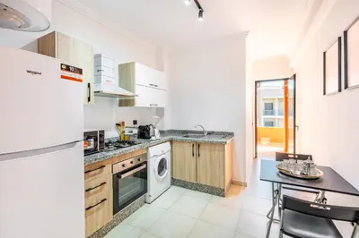 a kitchen with a washer and dryer and a table at Appartement Élégant Quartier Hivernage in Marrakech