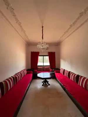 a room with red cushioned chairs and a table at Palmeraie Cozy Apartment in Marrakech