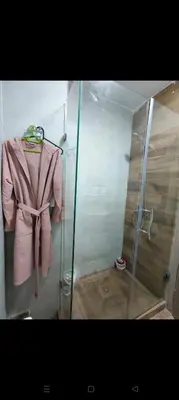 a pink robe is hanging in a shower at Casa della calma in Marrakech