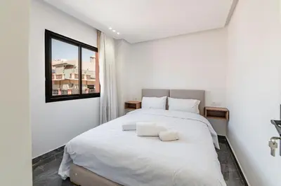 a bedroom with a large white bed with a window at Appartement 3 Chambres Luxe au Cœur de Guéliz in Marrakech