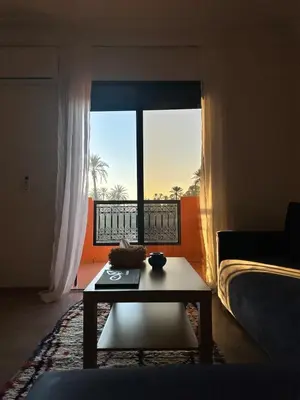 a living room with a table in front of a window at Serenity Loft in Marrakech
