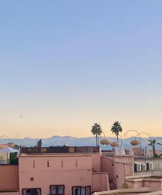 a view from the roof of a building with palm trees at Dar Aji, votre maison d'architecte privatisée en médina in Marrakech