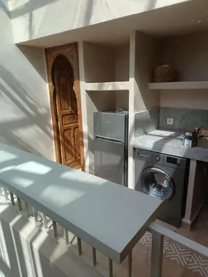 a kitchen with a refrigerator and a washing machine at Dar Aji, votre maison d'architecte privatisée en médina in Marrakech