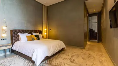a bedroom with a large bed with white sheets at Villa Marrakech, Piscine Privée, Sauna et Gym in Marrakech