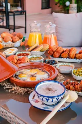a table topped with dishes of food and drinks at Villa Targaït - Luxury villa in Marrakech bliss in Marrakech