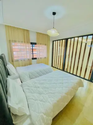 a bedroom with a large bed and two windows at duplex 3 Rom with spacious Guéliz victor hugo spacieuse in Marrakech