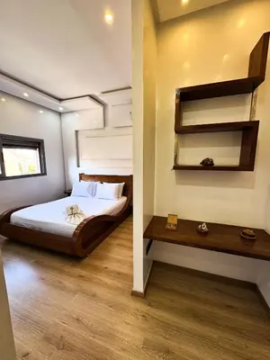 a bedroom with a bed and a wooden floor at Villa de luxe, à 20 minutes de Jamaa El Fna in Marrakech
