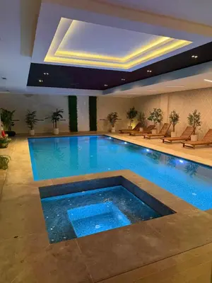 a large swimming pool in a hotel room with a large pool at Séjour Premium - Piscine, Jacuzzi, Chauffé et Salle de sport in Marrakech