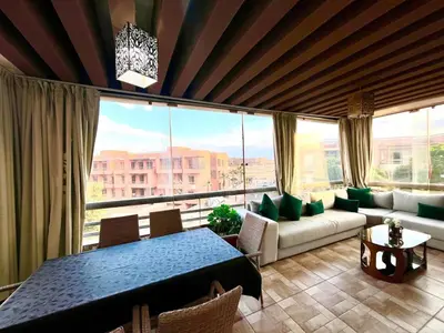a living room with a table and a large window at Red nelbrj appartement in Marrakech