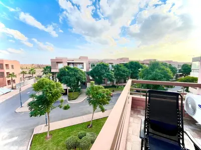 a balcony with a view of a street and trees at Red nelbrj appartement in Marrakech