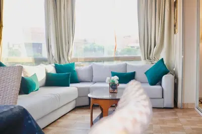 a living room with a white couch and a table at Red nelbrj appartement in Marrakech
