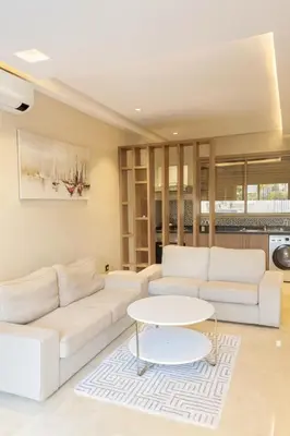 a living room with white couches and a table at Spacious Ground Floor Oasis with Pool & Golf Course View 1rom in Marrakech