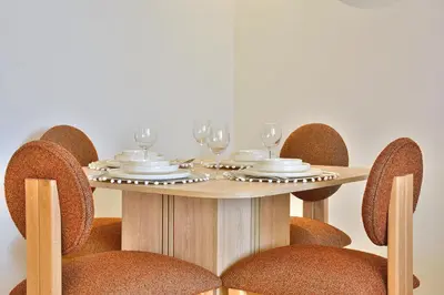 a wooden table with chairs and wine glasses on it at Noria Residence - Premium 2BR Apartment with Pool View in Marrakech