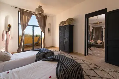 a bedroom with two beds and a large mirror at Fawakay Villas in Sfiani