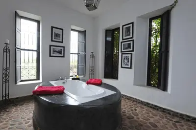 a large bathroom with a large tub in a room with windows at Fawakay Villas in Sfiani