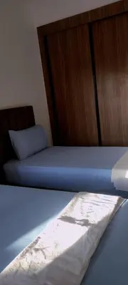 a bed with blue sheets and a wooden door at appartement Marrakech in Marrakech