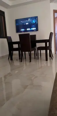 a dining room with chairs and a television on a wall at appartement Marrakech in Marrakech