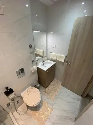 a bathroom with a sink and a toilet and a mirror at Élégant Appartement avec Suite à 10 min du centre in Marrakech