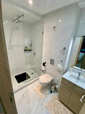 a bathroom with a shower and a toilet and a sink at Élégant Appartement avec Suite à 10 min du centre in Marrakech