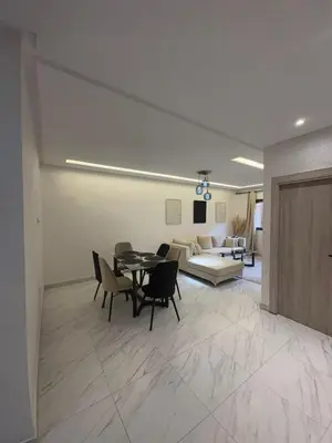 a living room with a table and chairs and a couch at Élégant Appartement avec Suite à 10 min du centre in Marrakech