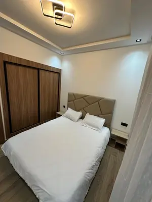 a bedroom with a large white bed with two pillows at Appartement cosy à Marrakech in Marrakech