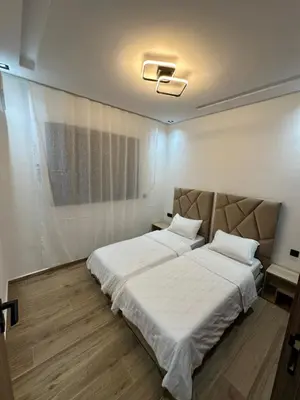 a bedroom with a large bed with white sheets at Appartement cosy à Marrakech in Marrakech
