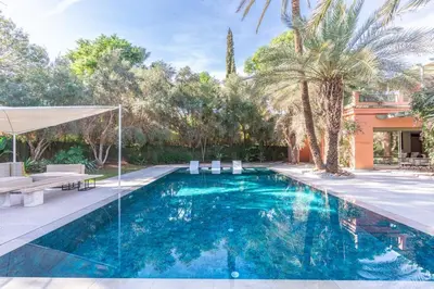 a swimming pool in a backyard with palm trees at Luxurious villa Marrakech La Palmeraie in Marrakech