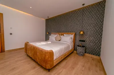 a bedroom with a large bed with a wooden headboard at Villa Lumeria in Marrakech