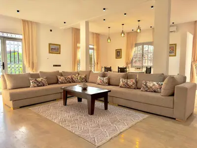 a living room with a couch and a coffee table at Charmante villa avec piscine privée et jardin in Marrakech
