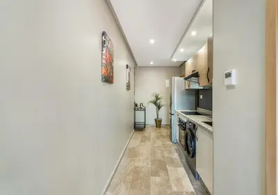 a hallway of a kitchen with a refrigerator at Appartement Chic & Neuf à Guéliz - Terrasse et Parking in Marrakech